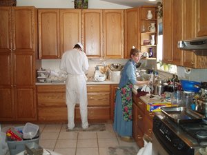 Steve and Kristina's mother mixing dough batches in the kitchen.