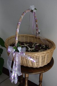 Basket of wedding favors--cute little pinecones with ribbons and dried flowers.