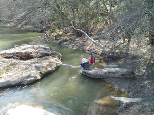 Danielle and Daniel trying to build a make-shift bridge to get to the other rock.