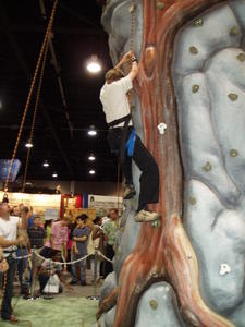 During the week, Levi had fun exploring the booth areas with Chelsey. Here he's going up the climbing wall.
