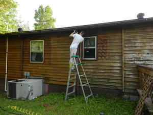 Daniel removing the downspout so he could take the window shutter off.