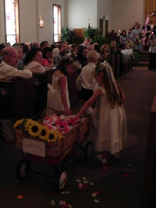 The Bible boy pulled the wagon, while the flower girls scattered the petals.