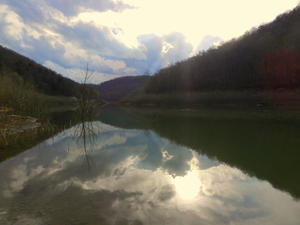 The sunshine peaking through the clouds reflecting on the water.