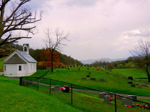 A cute little churchyard with the rain clouds in the distance.