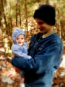 Daniel holding Janyssa on a walk in the woods.
