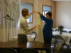 Kristina helping to steam iron table cloths.