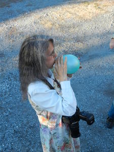 Amy blowing up a balloon.