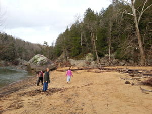 Walking along the sandy beach next to the river.